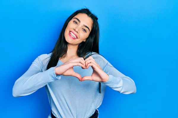 stock image Young hispanic girl wearing casual clothes smiling in love showing heart symbol and shape with hands. romantic concept. 