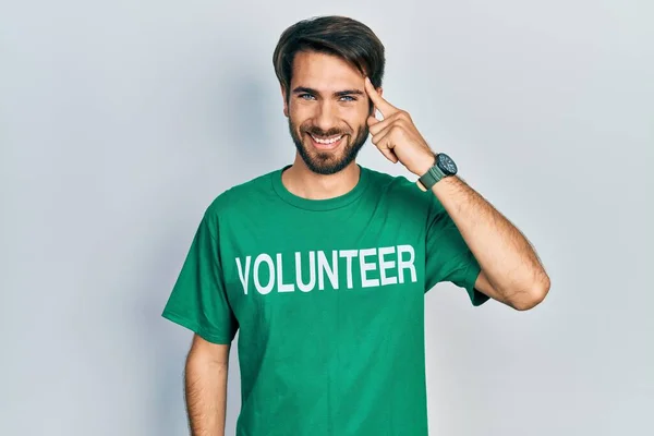Jovem Hispânico Vestindo Camiseta Voluntária Sorrindo Apontando Para Cabeça Com — Fotografia de Stock