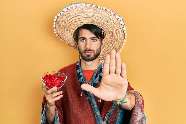 Jovem Hispânico Vestindo Chapéu Mexicano Segurando Chili Com Mão Aberta — Fotografia de Stock