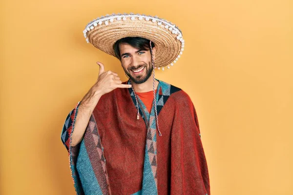 Jovem Hispânico Segurando Chapéu Mexicano Sorrindo Fazendo Gesto Telefônico Com — Fotografia de Stock