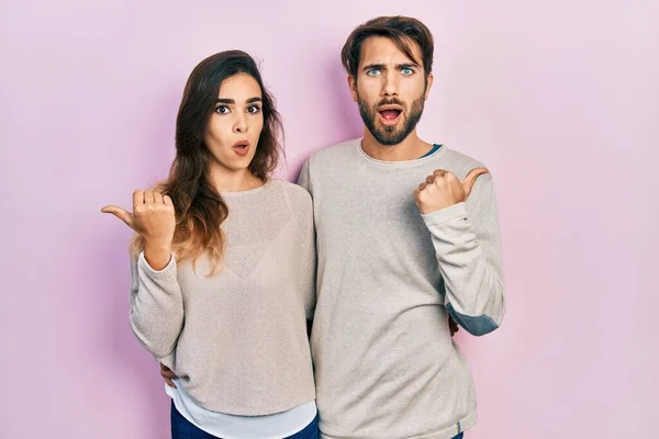 Junges Hispanisches Paar Lässiger Kleidung Überrascht Mit Zeigefinger Zur Seite — Stockfoto
