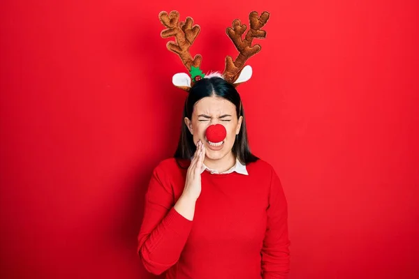Young Hispanic Woman Wearing Deer Christmas Hat Red Nose Touching — стоковое фото