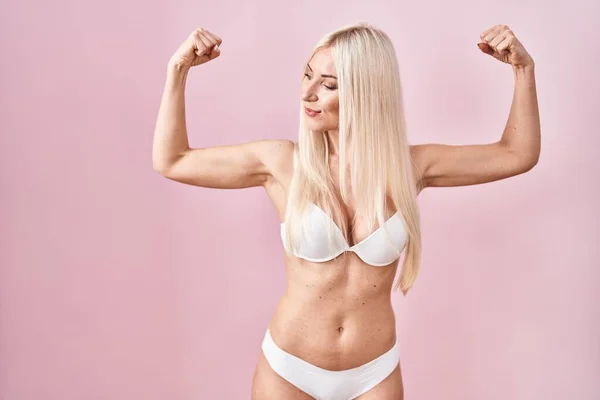 Caucasian Woman Wearing Lingerie Pink Background Showing Arms Muscles Smiling — стоковое фото