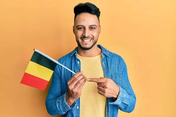 Ung Arabisk Man Håller Belgium Flagga Ler Glad Pekar Med — Stockfoto