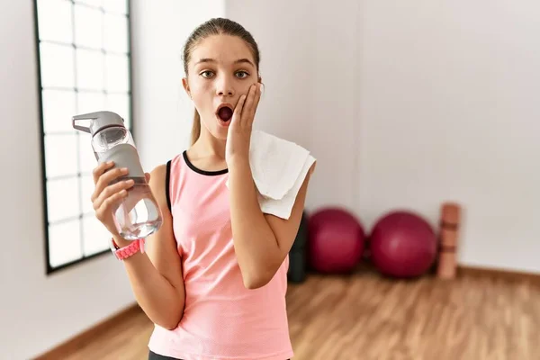Young Brunette Teenager Wearing Sportswear Holding Water Bottle Afraid Shocked — Stockfoto
