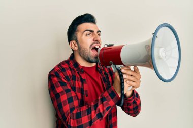 Sakallı İspanyol adam megafonla bağırıyor.