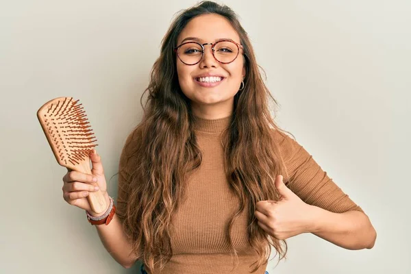 Joven Chica Hispana Sosteniendo Peine Pelo Sonriendo Feliz Positivo Pulgar —  Fotos de Stock