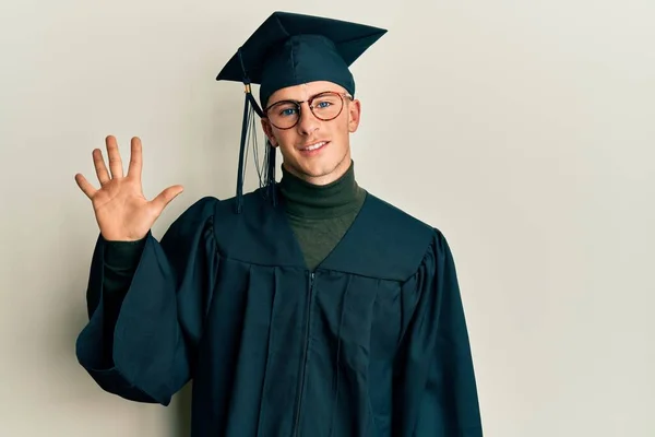 Young Caucasian Man Wearing Graduation Cap Ceremony Robe Showing Pointing — Stockfoto