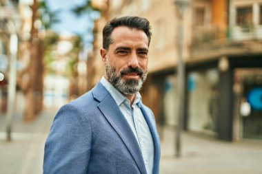 Orta yaşlı işadamı şehirde mutlu mesut dikilirken.