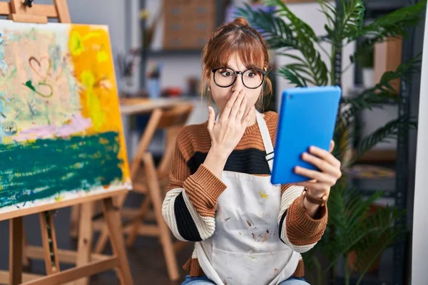 年轻美丽的女艺术家用手捂住嘴 用平板电脑进行视频通话 感到震惊和害怕犯错 惊讶的表情 — 图库照片