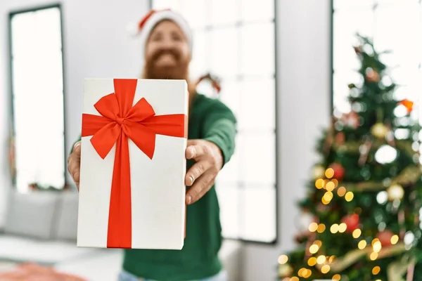 Young Redhead Man Holding Gift Standing Christmas Tree Home — Stock Photo, Image