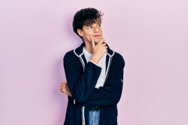 Yakışıklı hippi genç adam, günlük beyaz tişört ve sweatshirt giyiyordu. Düşünceleri şüphe üzerine yoğunlaşmıştı. Parmakları çenesinde ve yukarı bakıyordu. 