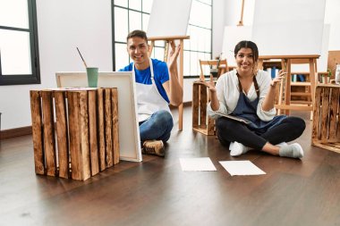 Sanat stüdyosundaki genç İspanyol çift zaferi mutlu bir gülümseme ve kazanan yüz ifadesiyle kutluyor. 