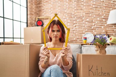 Yeni evinde kanepede oturan beyaz bir kadın şüpheci ve gergin, sorun yüzünden surat asıyor. negatif kişi. 