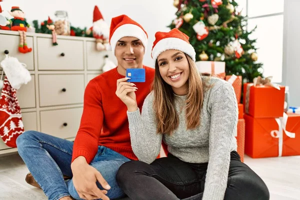 Casal Jovem Sorrindo Feliz Usando Chapéu Natal Sentado Chão Segurando — Fotografia de Stock