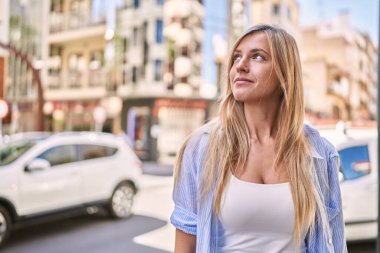 Sokakta kendine güvenen genç sarışın kadın gülümsüyor