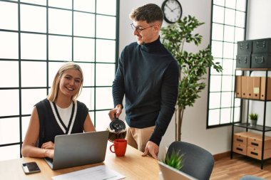 Ofiste çalışırken ve kahve içerken gülümseyen iki iş adamı..