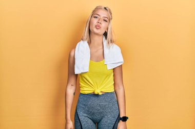 Spor kıyafeti giyen güzel sarışın kadın canlı yayında öpüşürken kameraya bakıyor. Güzel ve seksi. aşk ifadesi. 