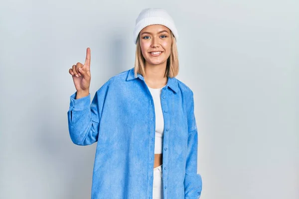 Beautiful Blonde Woman Wearing Wool Hat Showing Pointing Finger Number — Stockfoto