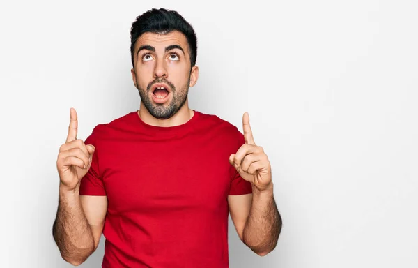 Hombre Hispano Con Barba Vistiendo Casual Camiseta Roja Asombrado Sorprendido — Foto de Stock