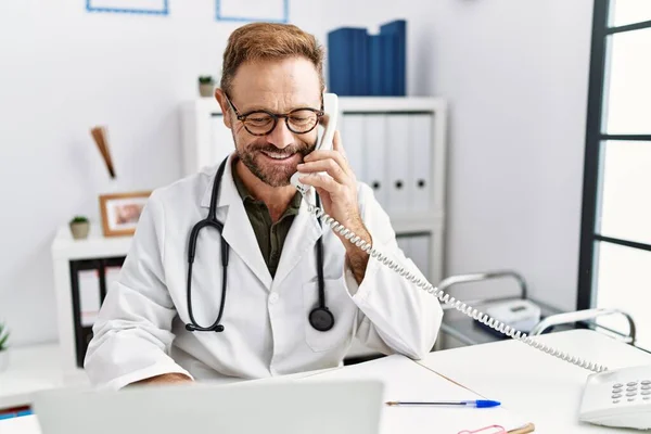 Homem Hispânico Meia Idade Vestindo Uniforme Médico Falando Telefone Clínica — Fotografia de Stock