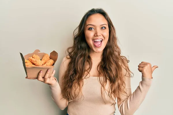 Ung Latinamerikansk Flicka Äter Kyckling Vingar Pekar Tummen Upp Till — Stockfoto