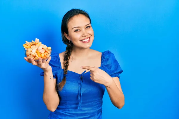 Ung Latinamerikansk Flicka Håller Skål Potatischips Leende Glad Pekar Med — Stockfoto