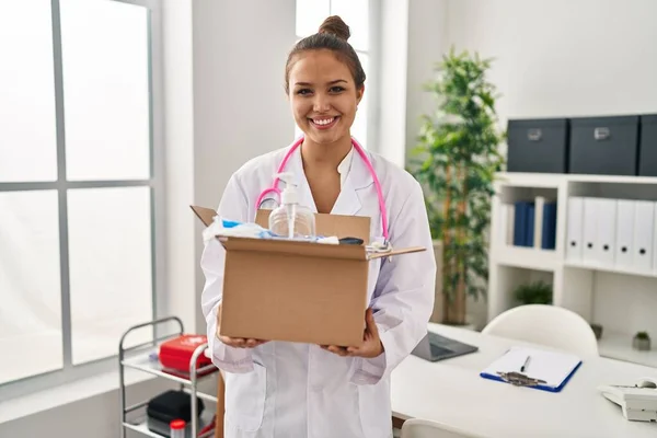 Young Hispanic Doctor Holding Box Medical Items Smiling Happy Cool — Stock Photo, Image