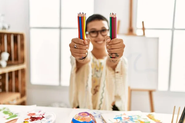 年轻的惊慌失措的女人带着自信的笑容在艺术工作室里拿着彩笔 — 图库照片