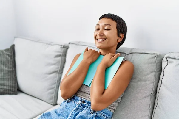 Jonge Latino Vrouw Glimlachen Zelfverzekerd Knuffelen Boek Thuis — Stockfoto