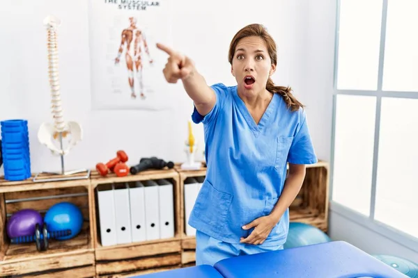 Middle Age Hispanic Physiotherapist Woman Working Pain Recovery Clinic Pointing — Stock Photo, Image