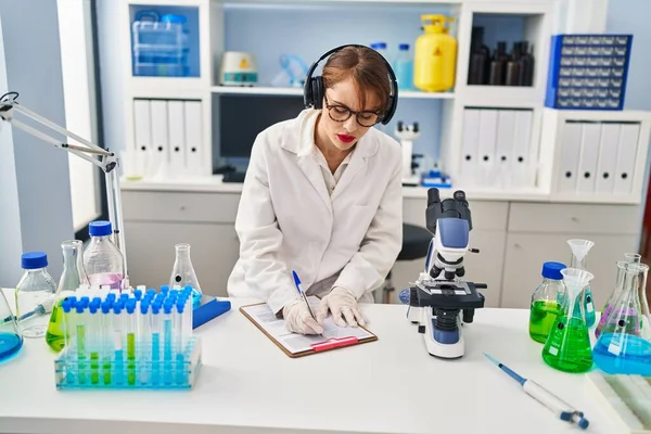 Молодая Белая Женщина Научной Форме Слушает Музыку Работающую Лаборатории — стоковое фото