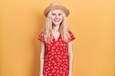 Güzel beyaz kadın, sarı saçlı, yaz şapkası takan, yüzünde mutlu ve havalı bir gülümseme olan. şanslı kişi. 