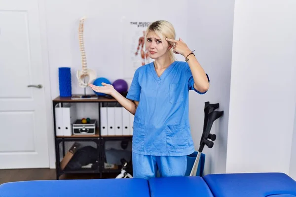 Jeune Physiothérapeute Femme Travaillant Clinique Récupération Douleur Confus Agacé Avec — Photo