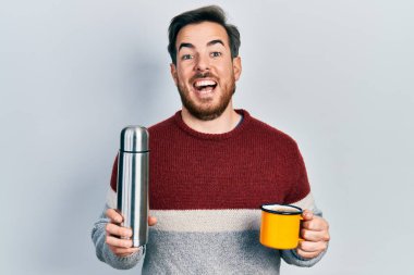 Sakallı yakışıklı beyaz adam bir fincan kahve içiyor, termo tutuyor çılgınlığı kutluyor ve başarıyı hayretle haykırıyor, heyecanla haykırıyor. 