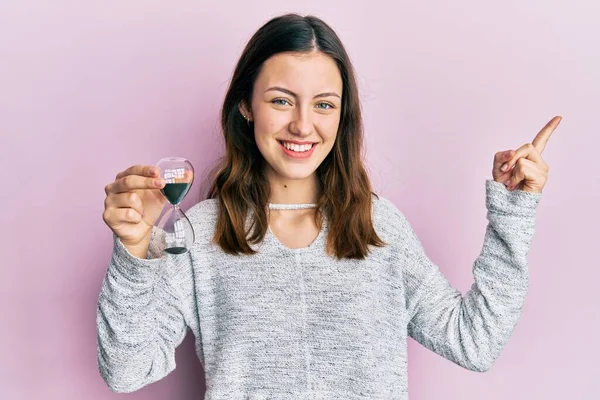 Kum Saati Tutan Genç Esmer Kadın Mutlu Bir Şekilde Gülümsüyor — Stok fotoğraf