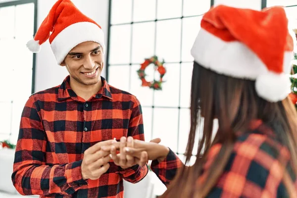 若いラテンカップル祝うクリスマス開催婚約指輪のために結婚式提案で家 — ストック写真