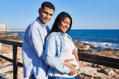 Genç, Latin bir çift bebek bekliyor. Birbirlerine sarılıyorlar.