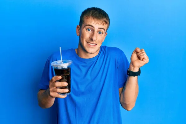 Joven Hombre Caucásico Bebiendo Vaso Bebida Gaseosa Gritando Orgulloso Celebrando —  Fotos de Stock