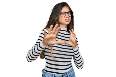 Genç, güzel, sıradan kıyafetler ve gözlük takan, tiksindirici bir ifade takınan, tiksinti reaksiyonu yüzünden tiksinmiş ve korkan bir genç kız. Eller havada. 