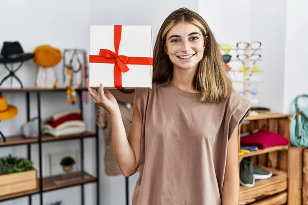 Young Blonde Woman Working Manager Retail Boutique Holding Gift Looking — Stock Photo, Image