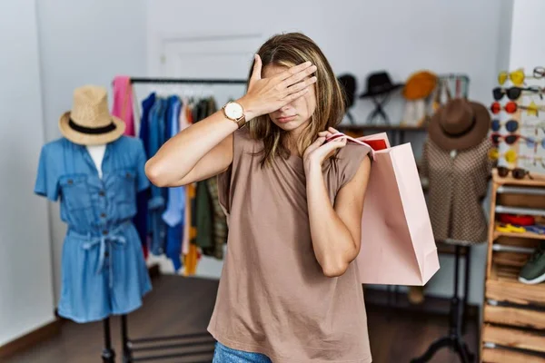 手で目を覆う小売店で買い物袋を持っている若いブロンドの女性は 真剣に悲しい顔をしています 目立たず隠し拒否の概念 — ストック写真