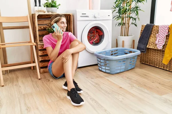 Çamaşır Odasında Çamaşır Makinesini Bekleyen Beyaz Bir Kadın Akıllı Telefondan — Stok fotoğraf