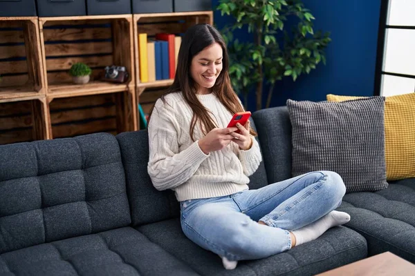 Jovem Mulher Usando Smartphone Sentado Sofá Casa — Fotografia de Stock