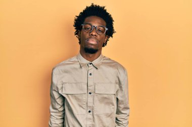 Sıradan kıyafetler ve gözlük takan genç Afro-Amerikan adam yüzünde ciddi bir ifadeyle rahatladı. Basit ve doğal bir şekilde kameraya bakıyorsun.. 