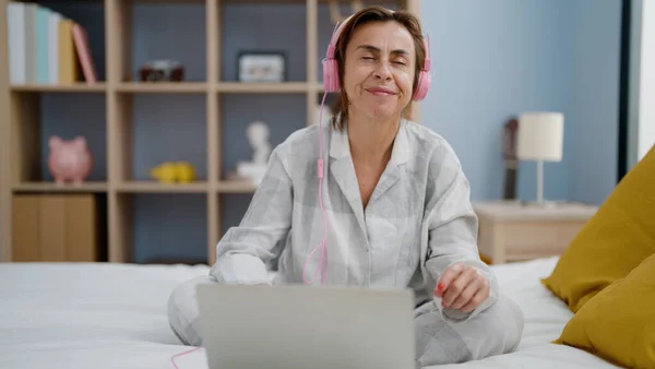 Middelbare Leeftijd Spaanse Vrouw Luisteren Naar Muziek Zitten Bed Slaapkamer — Stockfoto