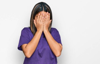 Genç İspanyol kız günlük mor tişörtler giyiyor ve ağlarken suratını ellerle kapatıyor. depresyon kavramı. 