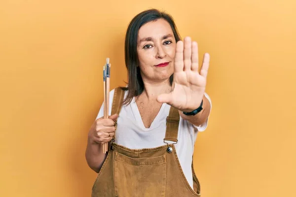 Medelålders Latinamerikansk Kvinna Håller Pensel Med Öppen Hand Gör Stopp — Stockfoto