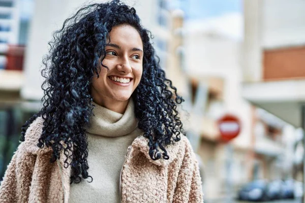 Sokakta kendinden emin gülümseyen genç İspanyol kadın.