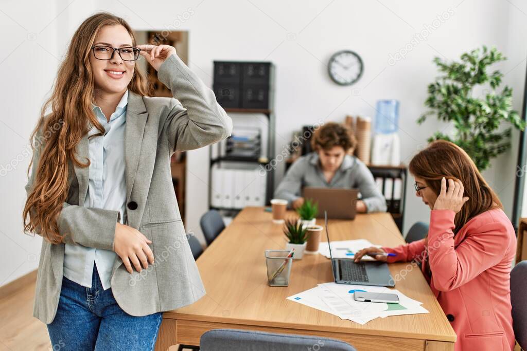 Manager smiling happy holding glasses. Business employees working at the office.
